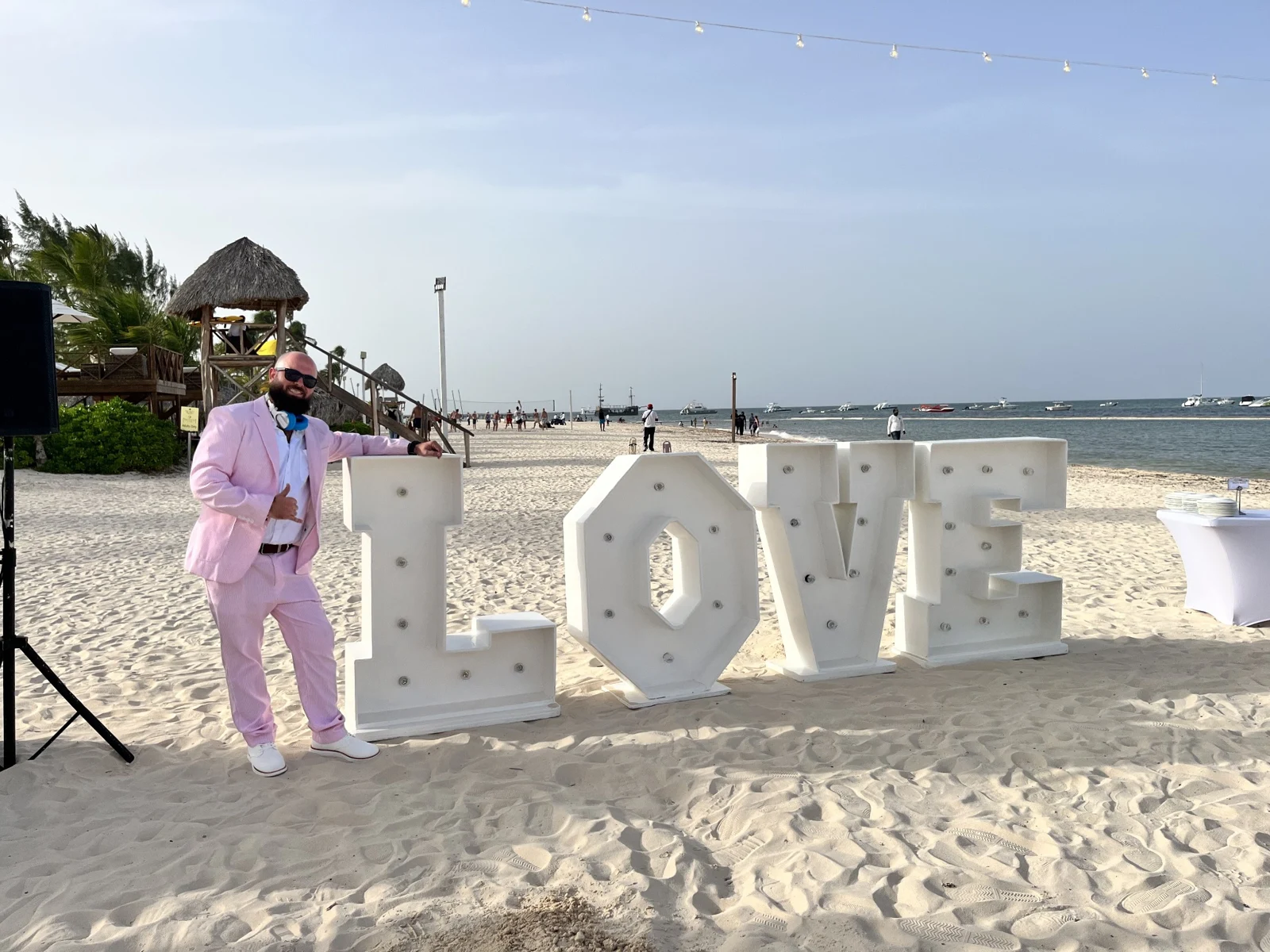 Kyle in a pink suit hosting a destination celebration by the beach