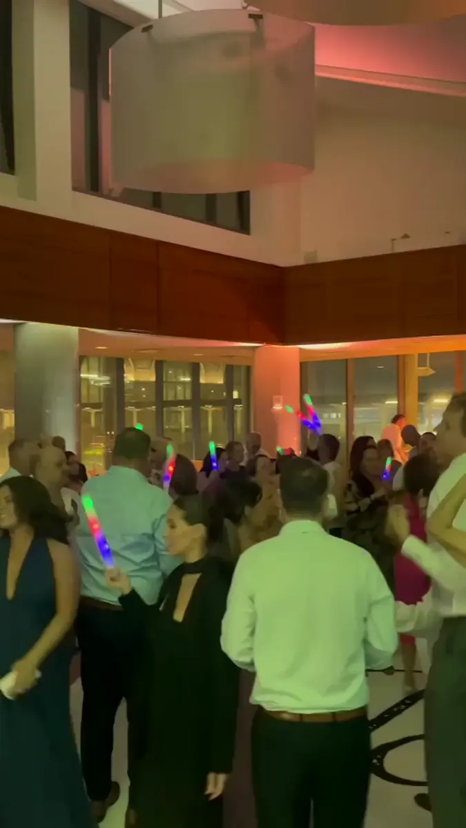 Guests dancing together under colorful lighting at an evening celebration